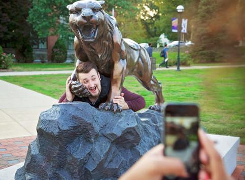Student Taking a Photo Bearcat Statue